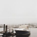A boat docked in a foggy Northeast harbor