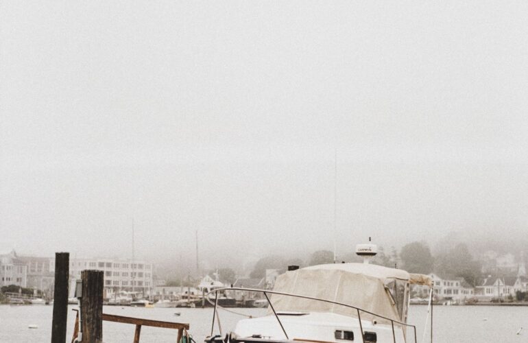 A boat docked in a foggy Northeast harbor